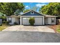 A well-maintained single-story home with a double car driveway, garage doors, and mature landscaping at 3741 Appleton Ct, Palm Harbor, FL 34684