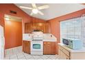 Bright kitchen with white countertops, matching appliances, and wooden cabinets under a vaulted ceiling at 3741 Appleton Ct, Palm Harbor, FL 34684