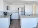 Modern kitchen featuring white cabinets, granite countertops, stainless steel appliances, and a kitchen island at 4009 Triggerfish Dr, Hernando Beach, FL 34607