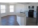 Bright kitchen with a large island, granite countertops, stainless steel appliances, and wood flooring at 4009 Triggerfish Dr, Hernando Beach, FL 34607