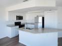 Bright kitchen featuring white cabinets, granite countertops, stainless steel appliances, and a kitchen island at 4009 Triggerfish Dr, Hernando Beach, FL 34607