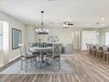 Open-concept dining room with wood floors, modern chandelier, and views into the living area, perfect for entertaining at 4237 Marine Pkwy, New Port Richey, FL 34652