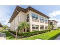 Exterior shot of two-story condo building with manicured lawn and mature trees at 4557 Garnet Dr # 102, New Port Richey, FL 34652