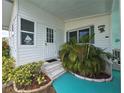 Close-up of home's entrance, showcasing the door, stairs and tropical landscaping for curb appeal at 5102 Pigeon Plum Cir, New Port Richey, FL 34653