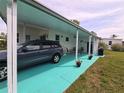 Exterior shot of the home with covered parking, a patio area, and space for outdoor activities at 5102 Pigeon Plum Cir, New Port Richey, FL 34653