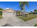 Inviting single-story home with a well-kept lawn and a spacious driveway leading to an attached garage at 5412 Merkin Pl, New Port Richey, FL 34655