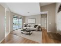 Bright living room featuring wood floors, neutral walls, comfortable seating, and sliding glass doors to the lanai at 5412 Merkin Pl, New Port Richey, FL 34655