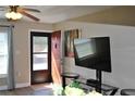 Comfortable living room featuring a ceiling fan, modern lighting, and an inviting entryway with hardwood style flooring at 6037 Chesham Dr # 3, New Port Richey, FL 34653