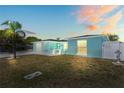 Beautiful light blue one-story home with a manicured lawn, palm tree, and a welcoming exterior at 7221 Westwind Dr, Port Richey, FL 34668