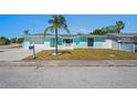 Beautiful one-story house with a light blue exterior, a lovely palm tree, and a well-kept lawn at 7221 Westwind Dr, Port Richey, FL 34668
