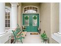 Inviting front entrance featuring double doors adorned with clover decorations and a charming seating area at 7511 Melogold Cir, Land O Lakes, FL 34637