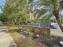 Exterior view of community signage with lush landscaping and mature trees at 861 Maple Ct # 205, Dunedin, FL 34698