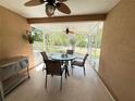 Enclosed patio features a ceiling fan and outdoor dining set overlooking the backyard at 9348 Villa Entrada, New Port Richey, FL 34655