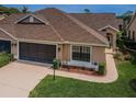 Charming home featuring a well-manicured lawn, brown trim, and an attached two-car garage at 9636 Brookdale Dr, New Port Richey, FL 34655