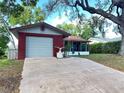 Charming home with a red brick facade, attached garage, and a screened-in porch at 10619 Mira Vista Dr, Port Richey, FL 34668