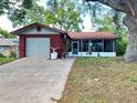 Charming home with a red brick facade, attached garage, and a screened-in porch at 10619 Mira Vista Dr, Port Richey, FL 34668
