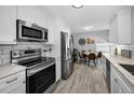 Bright kitchen features stainless steel appliances, white cabinets, and a breakfast nook at 1074 Woodbrook S Dr, Largo, FL 33770