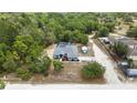 Expansive aerial view showcasing the house with a screened pool, complemented by lush trees and scenic landscape at 11379 Flower Ave, Weeki Wachee, FL 34613