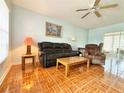 Cozy living room featuring tiled floors, ceiling fan, sofa and recliner set at 12037 Boynton Ln, New Port Richey, FL 34654