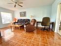 Cozy living room featuring tiled floors, ceiling fan, sofa and recliner set at 12037 Boynton Ln, New Port Richey, FL 34654