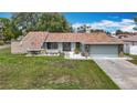 Charming single-story home featuring a well-manicured lawn and an attached two-car garage at 12087 Tallwood St, Spring Hill, FL 34608