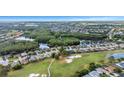 Aerial view of a home nestled in a community surrounded by golf courses and a scenic lake at 1517 Morning Rose Pl, Trinity, FL 34655