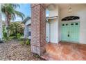 Welcoming front entrance with an eye-catching door, brick pillar and tile landing area at 1517 Morning Rose Pl, Trinity, FL 34655