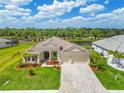 Beautiful single-Gathering home featuring a tile roof, manicured lawn and a brick paver driveway at 15912 42Nd E Gln, Parrish, FL 34219