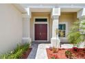 Grand entrance featuring a double door entry and elegant columns, framed by beautiful landscaping at 15912 42Nd E Gln, Parrish, FL 34219