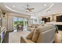 Spacious living room with tray ceiling, neutral color palette, and sliding glass doors to backyard at 15912 42Nd E Gln, Parrish, FL 34219