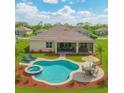 Aerial view of a backyard pool with a hot tub, covered patio with lounge seating, and an outdoor dining area at 15912 42Nd E Gln, Parrish, FL 34219