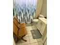 Modest bathroom featuring a forest-themed shower curtain, a toilet, and a single sink with vanity storage at 1704 Winn Arthur Dr, Valrico, FL 33594