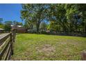 Expansive, fenced-in backyard featuring green grass and mature trees, ideal for outdoor activities and enjoying nature at 28330 Peterson Camp Rd, Brooksville, FL 34601