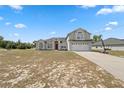 Daytime view of a two-story home featuring a paved driveway, two-car garage, and well-kept lawn at 3017 Aldoro Ave, Spring Hill, FL 34609