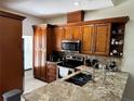 Well-appointed kitchen featuring wooden cabinets, granite countertops, and stainless steel appliances at 3037 Leroy W St, Tampa, FL 33607