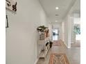 Inviting hallway features neutral paint, ceramic tile, and decor with a view of the living spaces at 4004 Autumn Amber Dr, Spring Hill, FL 34609