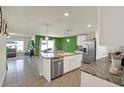 Bright kitchen features an island with a sink, granite counters, stainless steel appliances, and an open floor plan at 4004 Autumn Amber Dr, Spring Hill, FL 34609