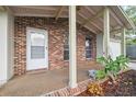 Welcoming front porch with brick accents, decorative plants, and a view of the attached garage at 4559 Crescent Rd, Spring Hill, FL 34606