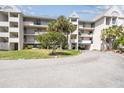 Condo building exterior with balconies, landscaping, and covered parking, showcasing its coastal charm at 5537 Sea Forest Dr # 301, New Port Richey, FL 34652