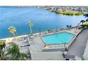 Beautiful waterfront pool with tables, chairs, and lounge chairs for relaxing by the water at 6035 Sea Ranch Dr # 305, Hudson, FL 34667