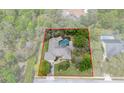 A beautiful aerial shot shows the home, featuring a screened pool and lush, mature landscaping at 6475 Laurel Oak Dr, Spring Hill, FL 34607