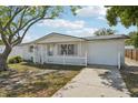 Cozy single-story home with a well-manicured lawn, white picket fence, and attached garage at 7034 N King Arthur E Dr # 4, Port Richey, FL 34668