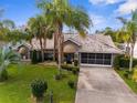 Well-maintained home with a tile roof, mature landscaping, and an attached garage at 8200 Rhanbuoy Rd, Spring Hill, FL 34606