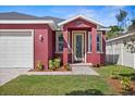 Close up of the front of a pink house with a brick walkway and landscaped yard at 8312 40Th N St, Pinellas Park, FL 33781