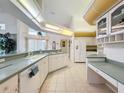 Bright kitchen with white cabinets, countertops, and tile flooring at 8606 Coral Creek Loop, Hudson, FL 34667