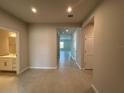 Open hallway view showcasing tile flooring, neutral paint, and a doorway leading to a bathroom at 10012 Zennia Ln, Parrish, FL 34219