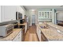 Bright kitchen with white cabinetry, stainless steel appliances and granite countertops at 11050 Kiskadee Cir, New Port Richey, FL 34654
