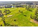 Scenic aerial view of a golf course with mature trees, sand traps and distant homes at 11524 Holly Ann Dr, New Port Richey, FL 34654