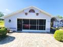 A home with a screened-in garage and a paver driveway at 13010 Siam Dr, Spring Hill, FL 34609