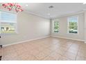 Bright and airy living room with large windows, neutral walls and beautiful tile flooring at 13366 Barkingside Pl, Spring Hill, FL 34609